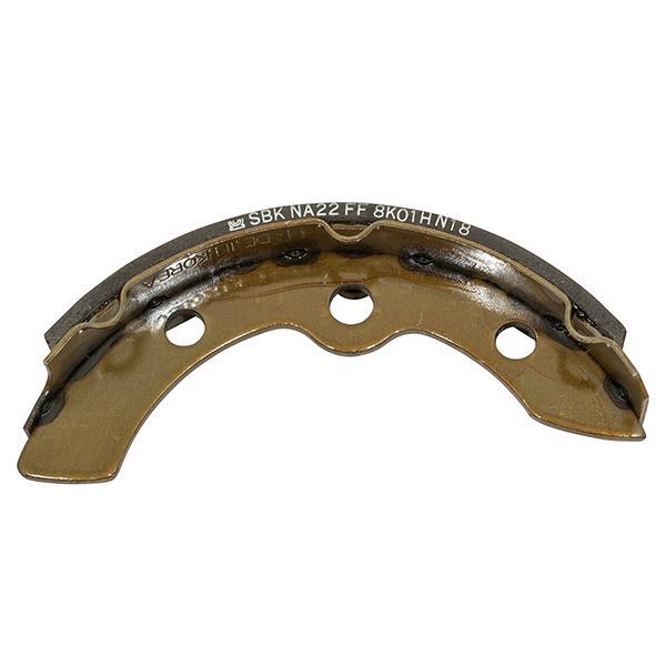 Inner face of one front brake shoe with three mounting holes and a stamped marking.